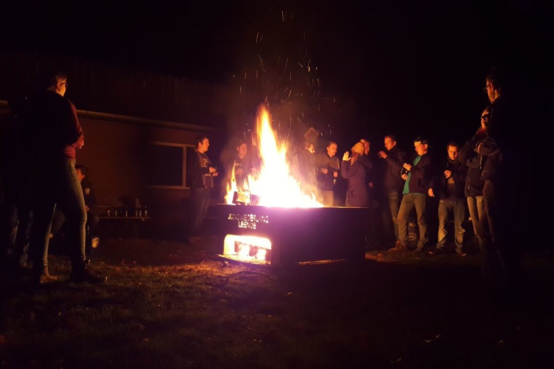 Deelnemers aan de Kamp/bivakcursus rond een kampvuur